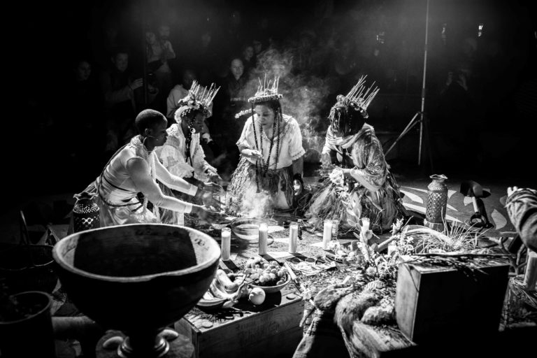 Four people gathered in a semicircle in a gun washing ceremony