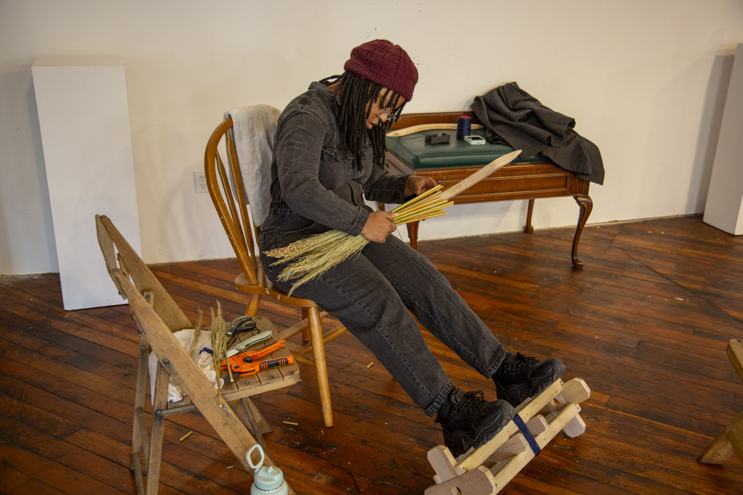Jasmine Best crafting brooms with sorghum. Photo by Billy Chen at Arts Letters & Numbers.
