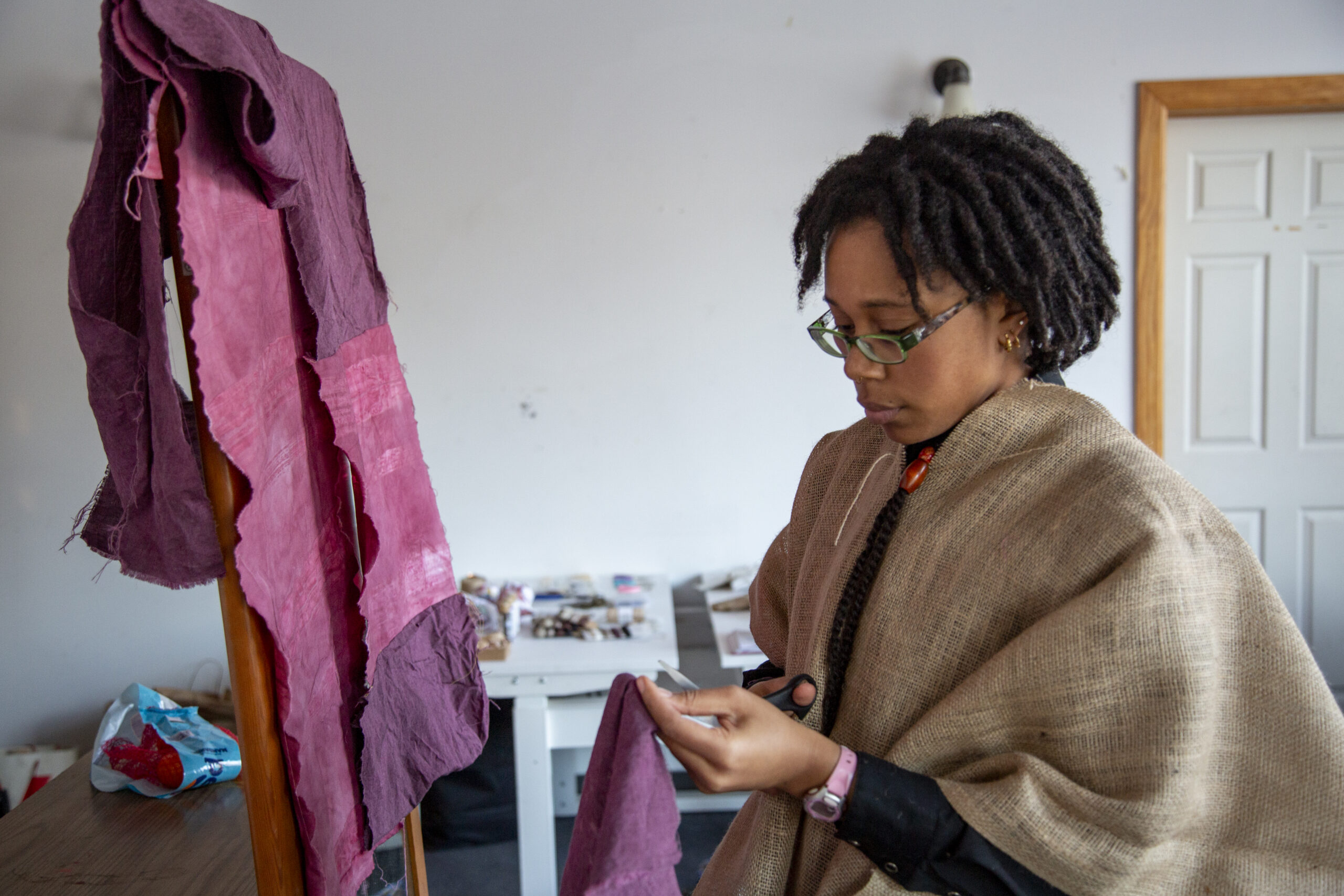 Cici Osias prepares garments for the dancers with raffia, marley hair, and burlap. Photo by Billy Chen at Arts Letters & Numbers.