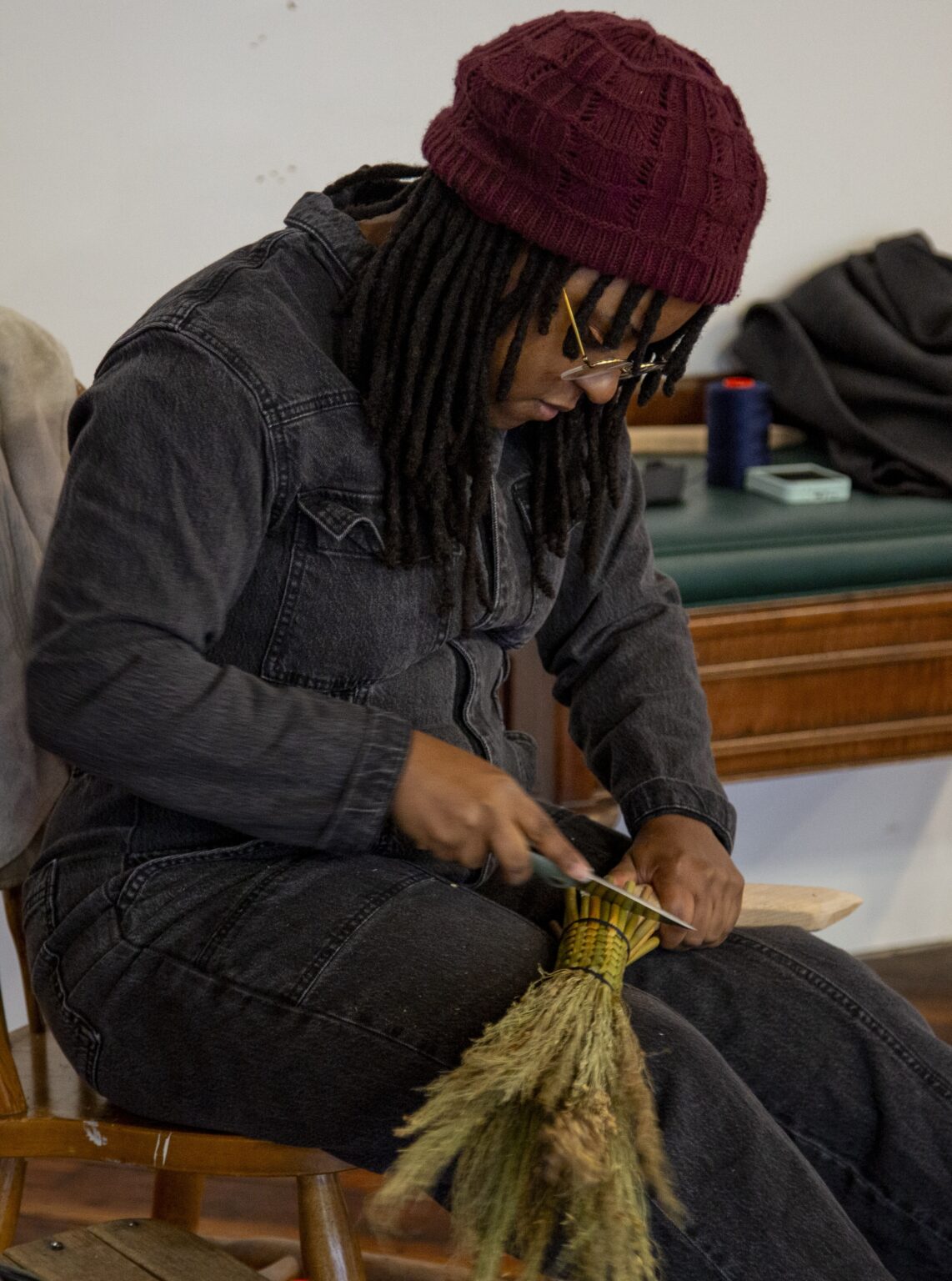 Jasmine Best preparing the Sorghum for their brooms. Photo by Billy Chen, courtesy of Arts Letters & Numbers.