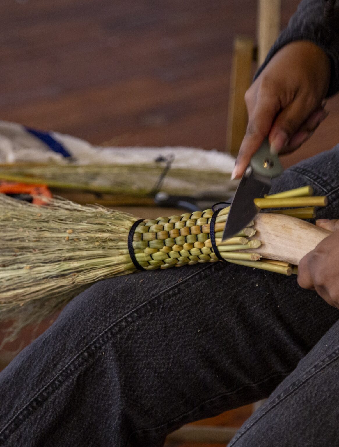 Jasmine Best preparing the Sorghum for their brooms. Photo by Billy Chen, courtesy of Arts Letters & Numbers.